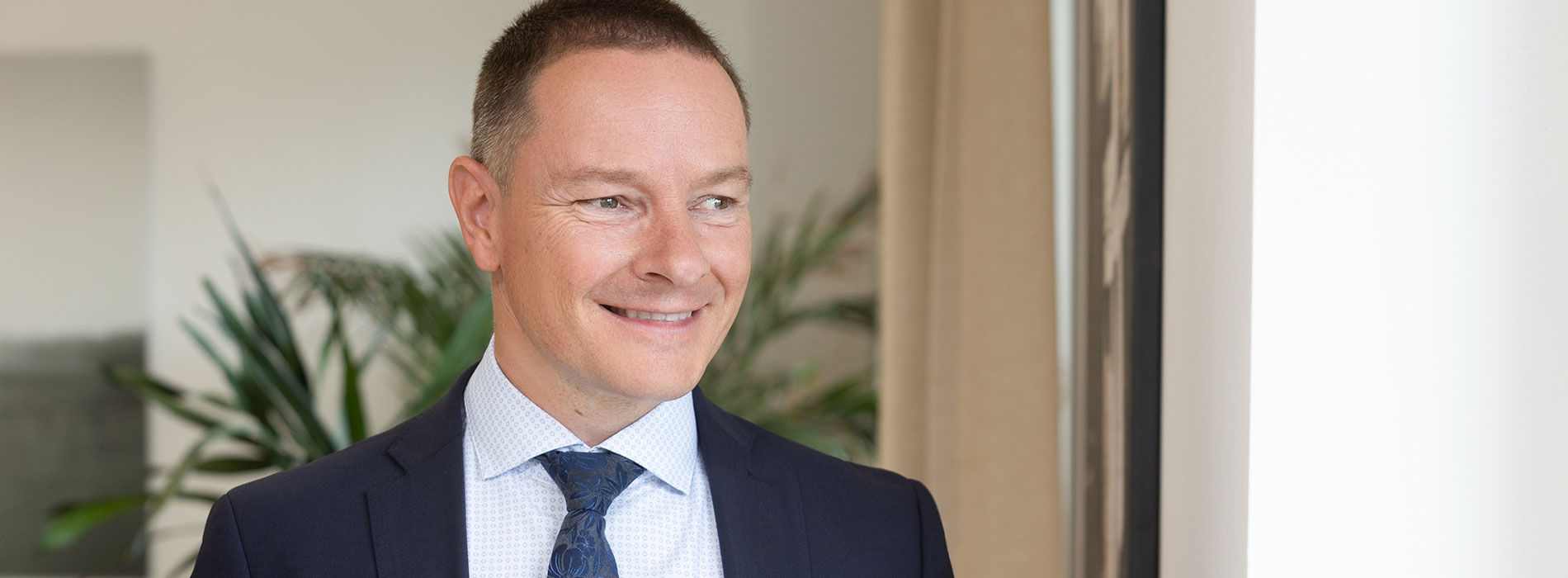 Dr Thomas Primig lächelt im Büro in Feldkirchen. Rechtsanwalt Rechtsanwaelte Anwalt Feldkirchen Kaernten
